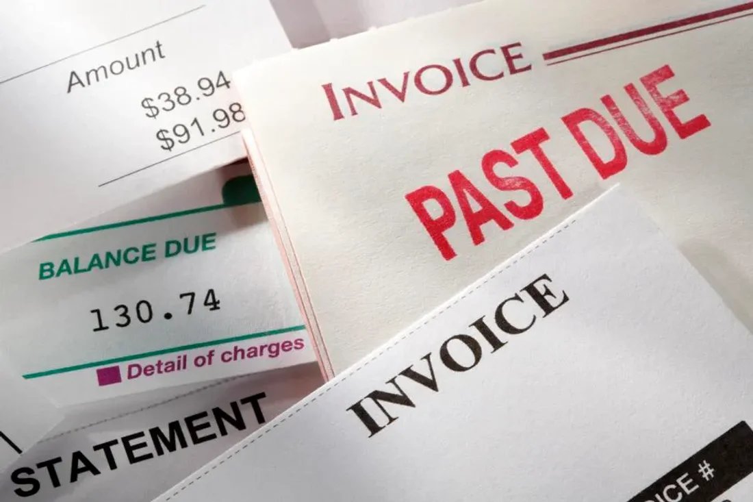 A stack of invoices with various items on them such as totals, taxes, and past due marks.