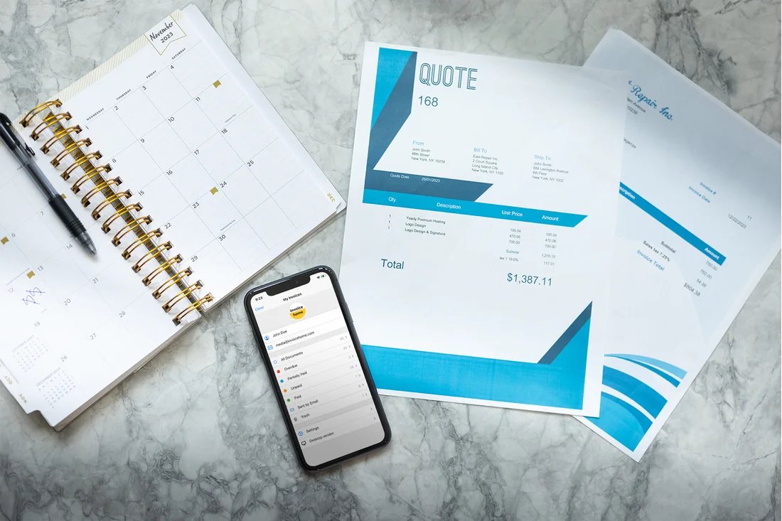Calendar, Invoices, and Invoice Home opened up on the screen of a phone on top of a table.